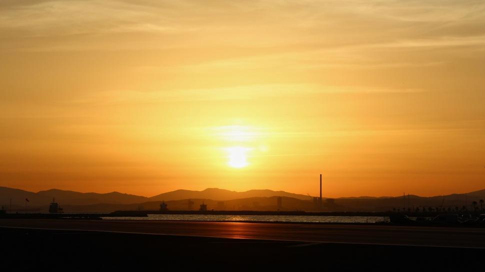 Free Image of Sun Setting Over Body of Water 