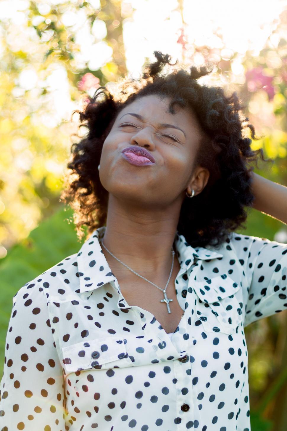 Free Image of Woman in Polka Dot Shirt Blowing Her Hair 