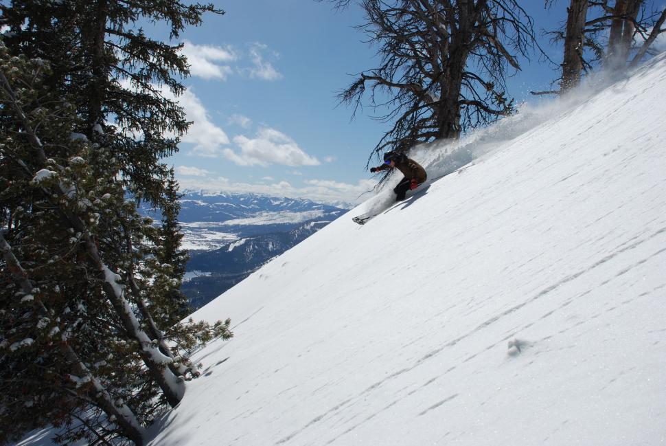 Free Image of Man Snowboarding Down Snow-Covered Slope 