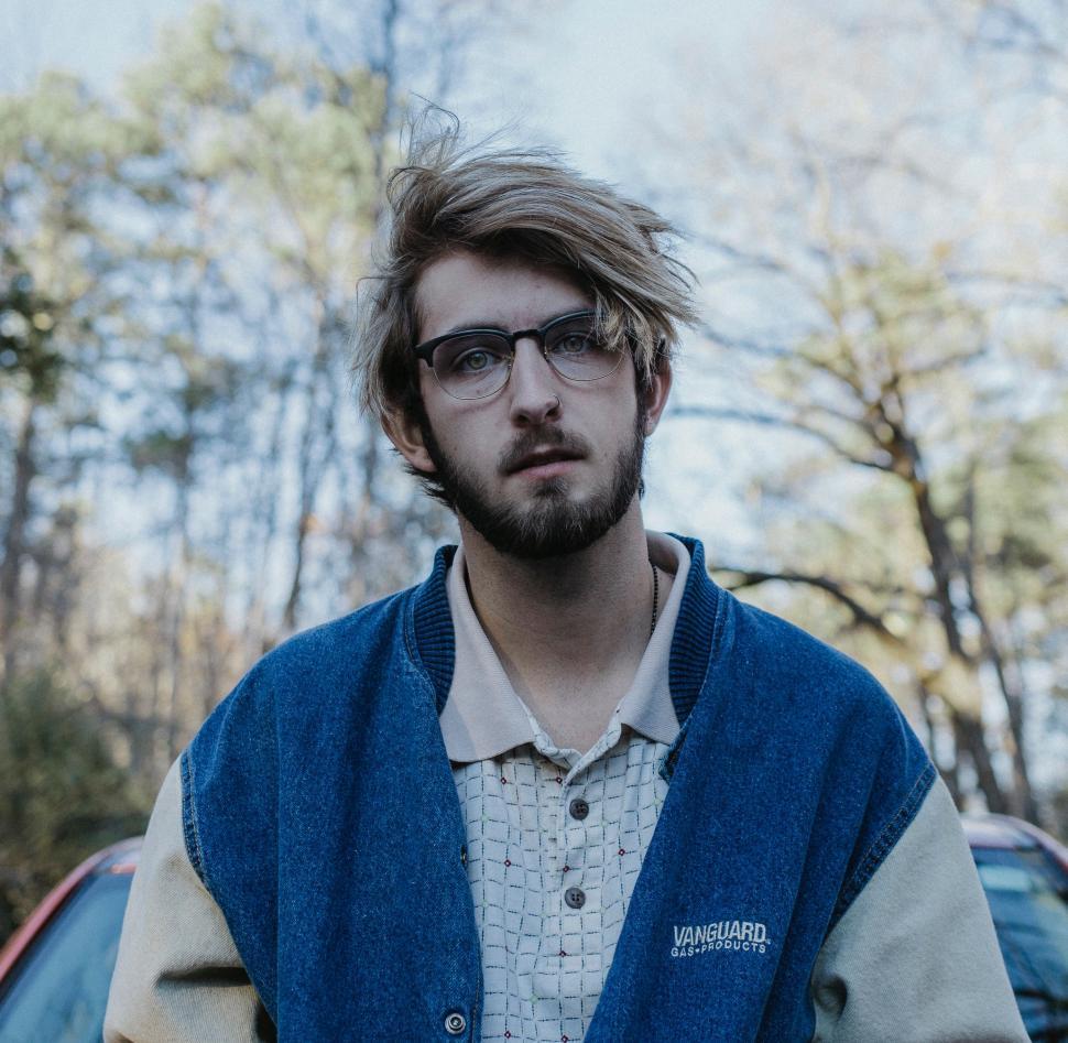 Free Image of Man With Glasses Standing in Front of Car 