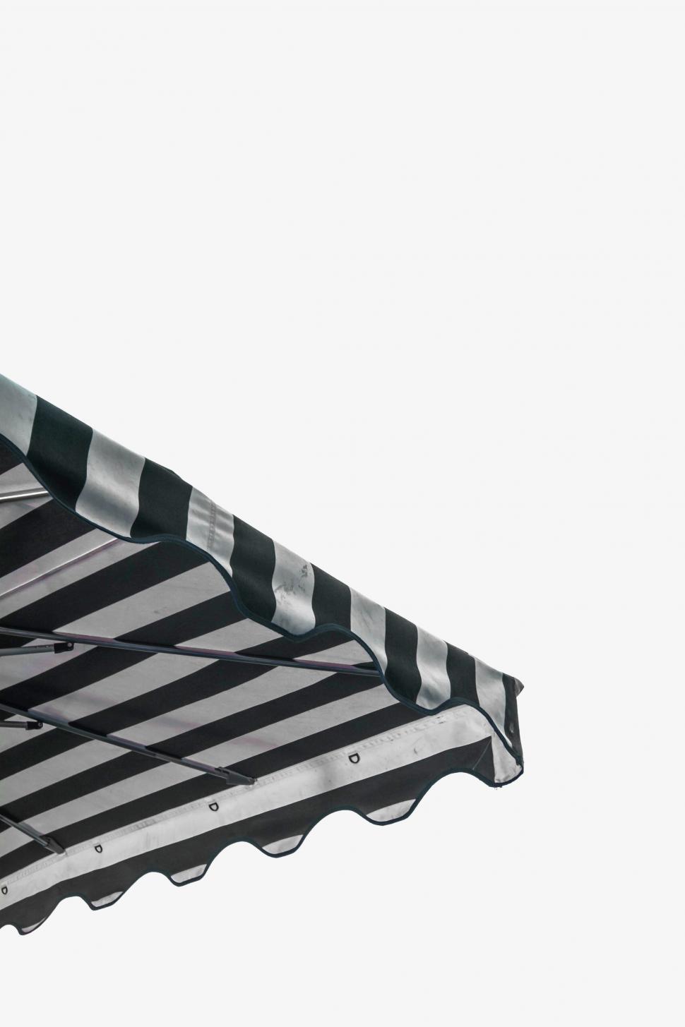Free Image of Large Black and White Striped Umbrella on White Background 