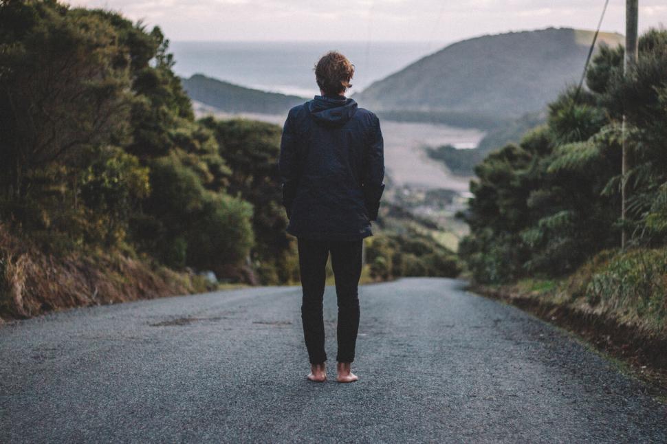 Free Image of Man Walking Down Road Towards Ocean 