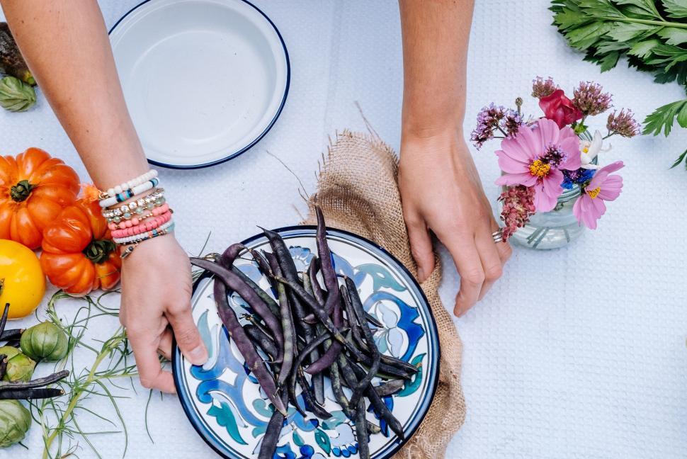Free Image of Person Holding Plate of Beans on Table 