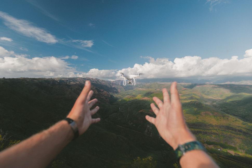 Free Image of Man Flying Kite Over Lush Green Hillside 