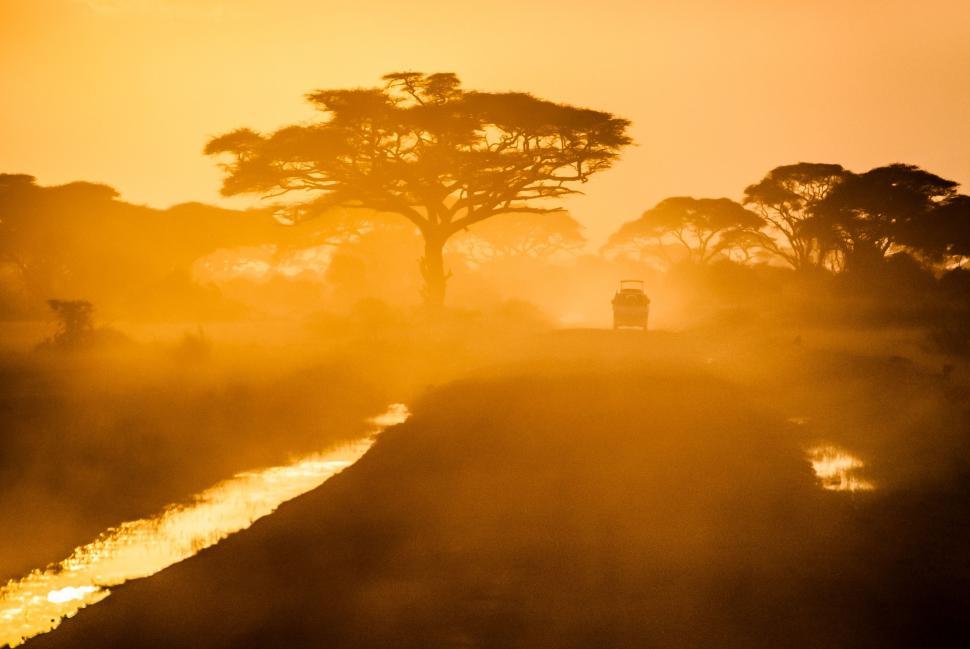 Free Image of Truck Driving Down a Dirt Road at Sunset 