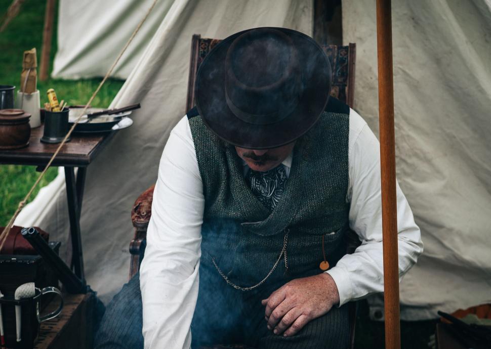 Free Image of Man Sitting in Chair in Front of Tent 