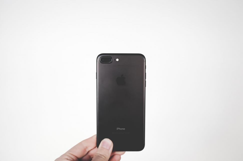 Free Image of Hand Holding Cell Phone Against White Background 