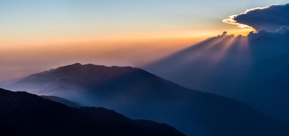 Free Image of Sun Shining Through Clouds in Mountain Landscape 