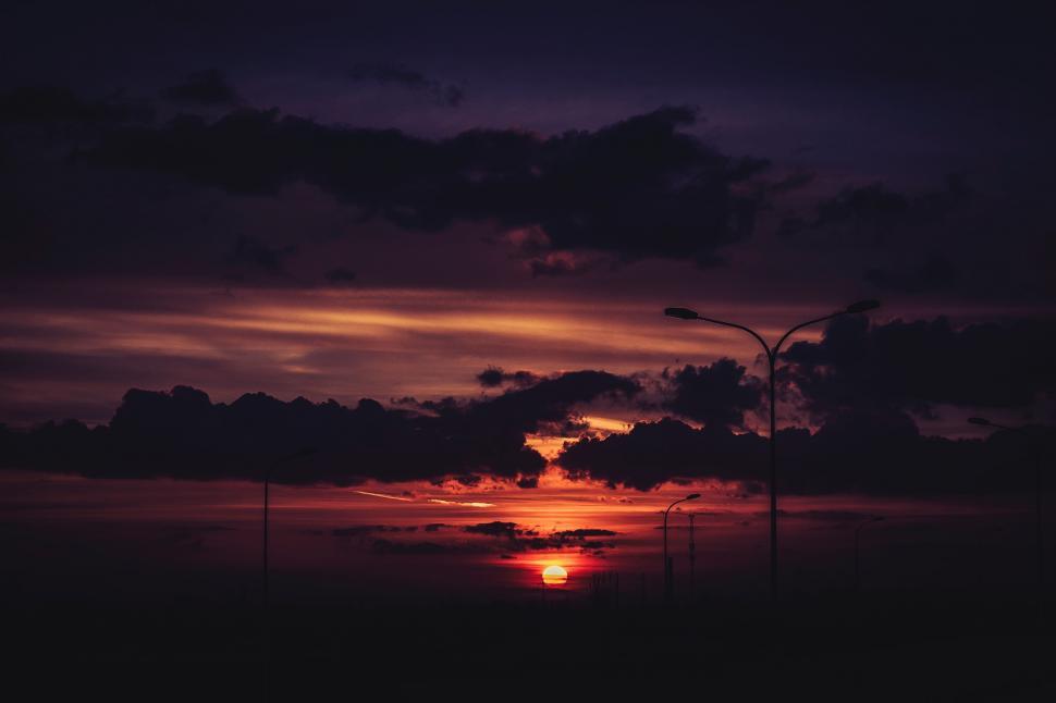 Free Image of The Sun Sets Over a Body of Water 