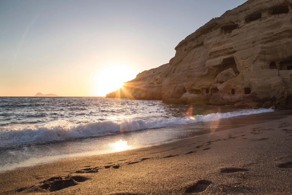 Free Image of Footprints in the Sand on a Beach at Sunset 