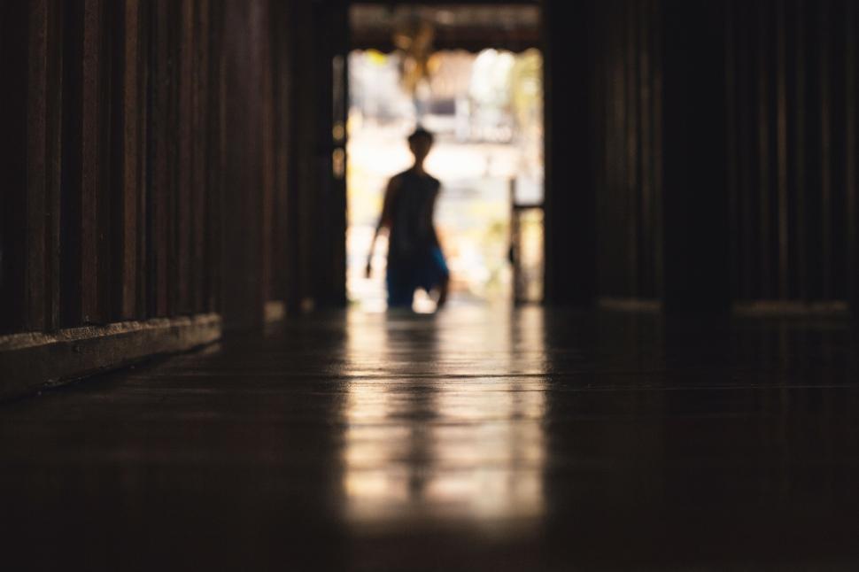 Free Image of Man Walking Down Hallway in Building 