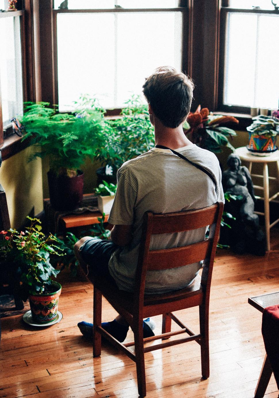 Free Image of Man Sitting in Chair by Window 