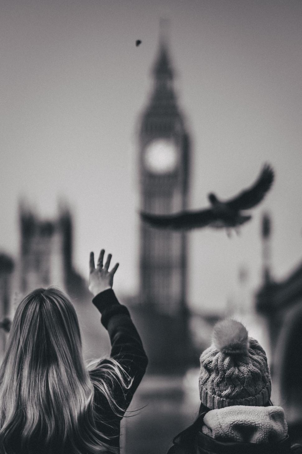 Free Image of Two People Standing in Front of Clock Tower 