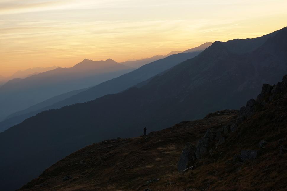 Free Image of Person Standing on Top of Mountain at Sunset 