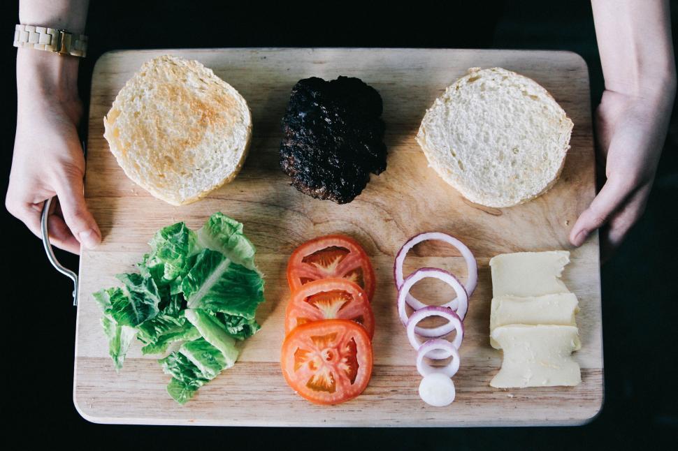 Free Image of Person Holding Cutting Board With Food 