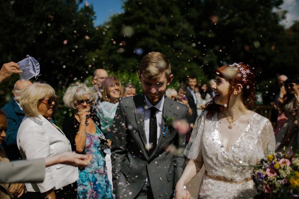 Free Image of Bride and Groom Walking Through Group of People 