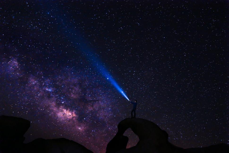 Free Image of Person Holding Flashlight Up to Sky 