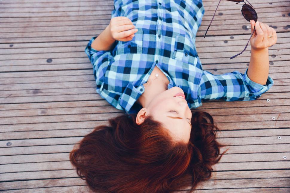 Free Image of Woman Laying on Ground With Sunglasses 