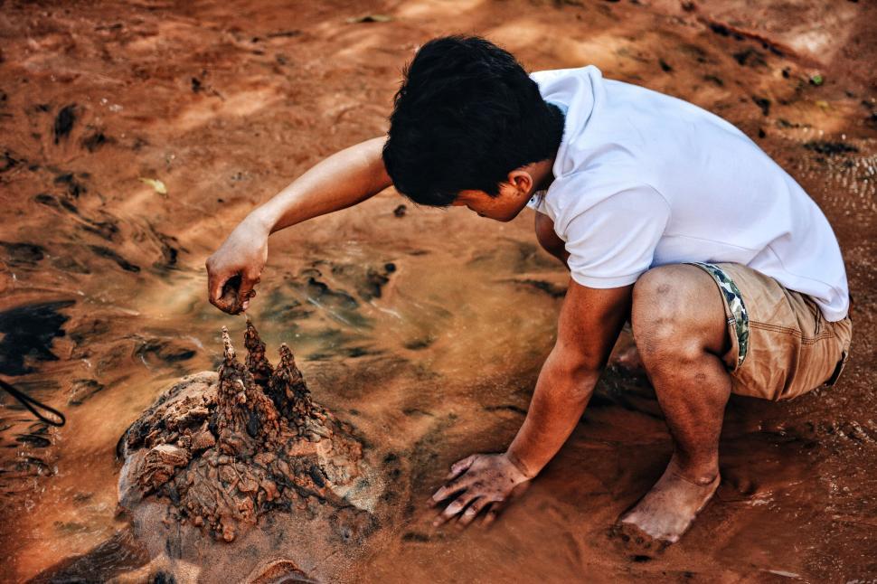 Free Image of Man Kneeling Next to Dead Animal 
