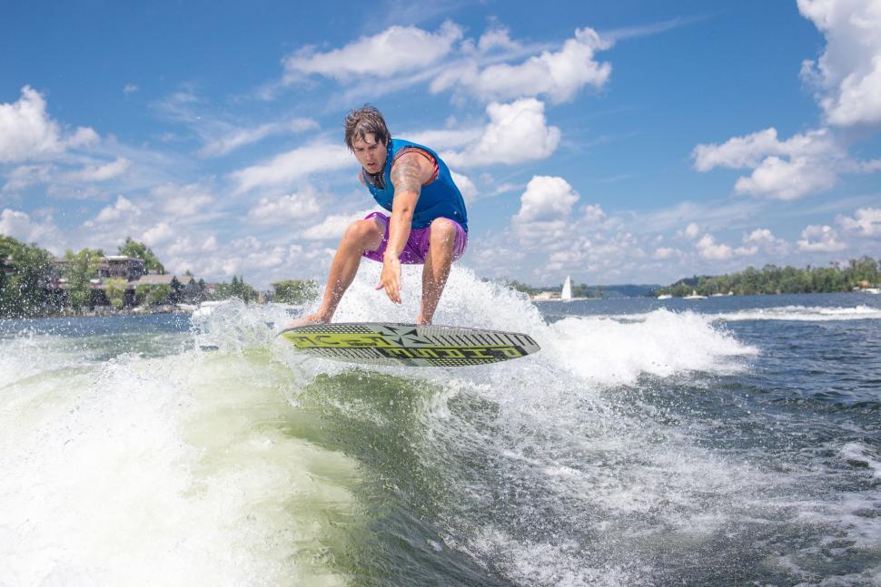 Free Image of Man Riding Wave on Surfboard 