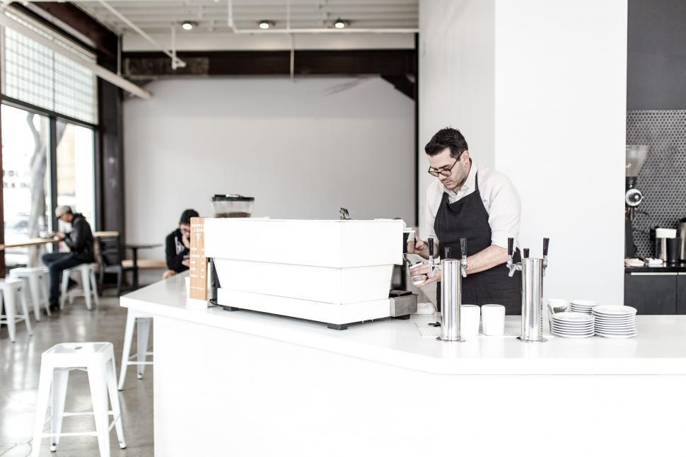 Free Image of Man Standing at Restaurant Counter 