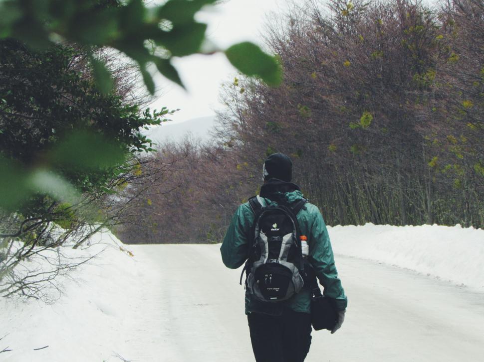 Free Image of Person Walking Down a Snow Covered Road 