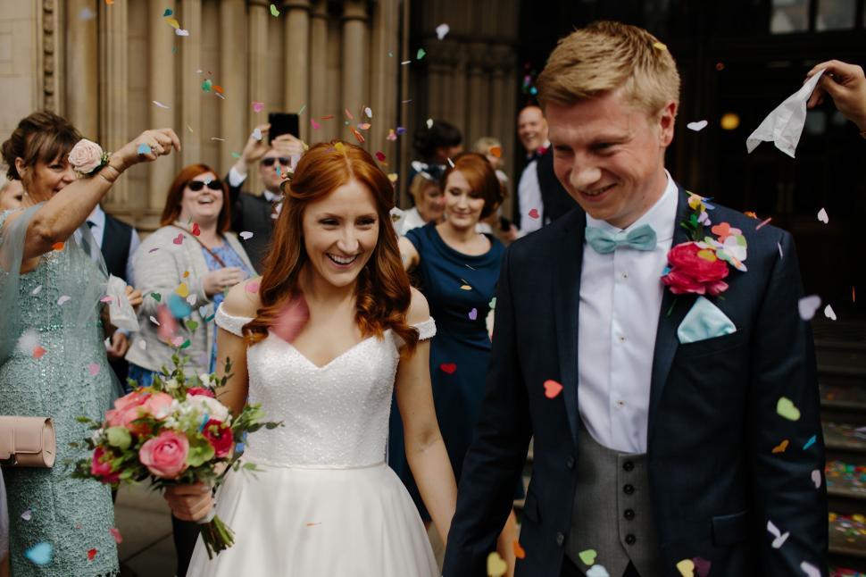 Free Image of Bride and Groom Walking Through Confetti 