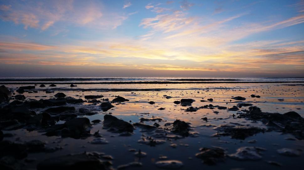 Free Image of Sun Setting Over Water at Beach 