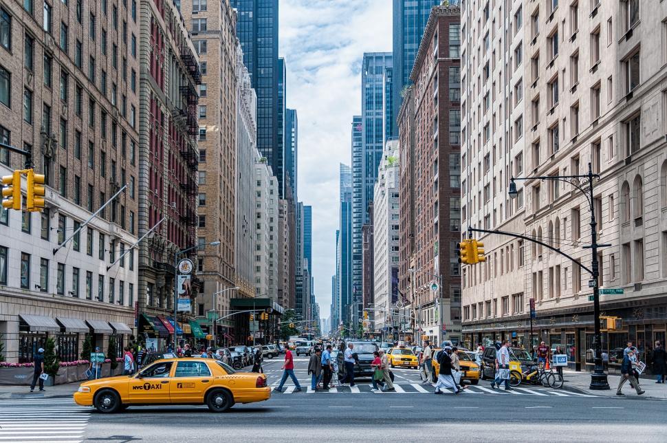 Free Image of Yellow Taxi Cab Driving Down City Street 