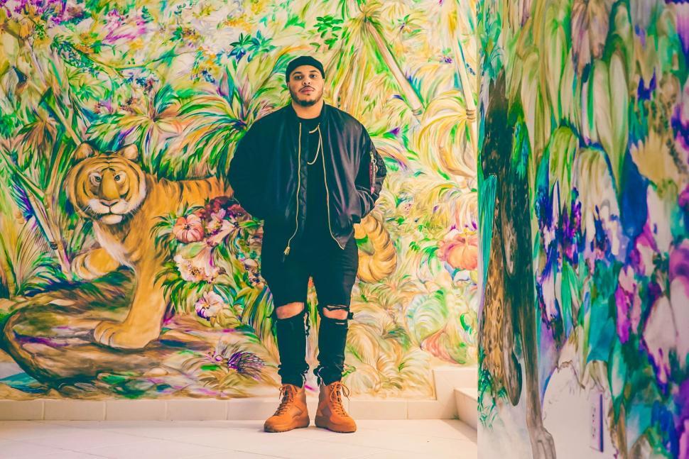 Free Image of Man Standing in Front of Painting of Tiger 