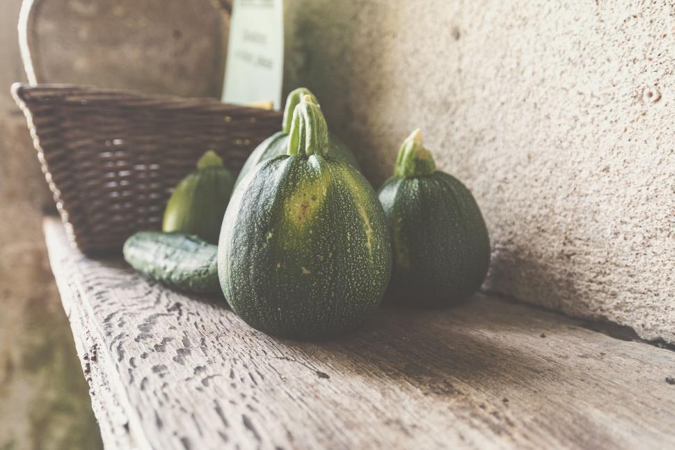 Free Image of Three Zucchini on a Bench Next to a Basket 
