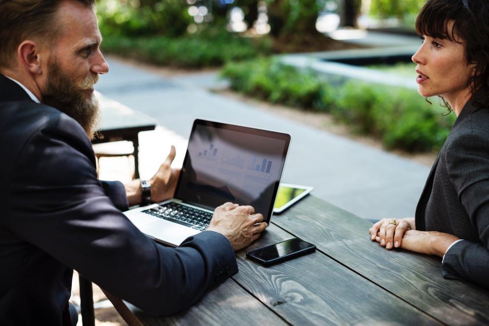 Free Image of Man and Woman Sitting at Table With Laptop 