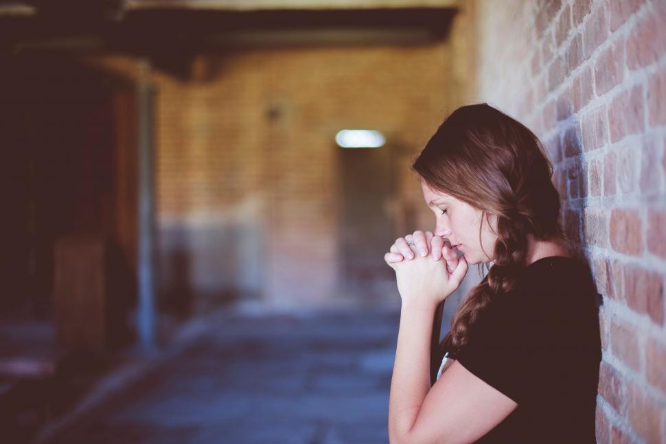 Free Image of Woman Standing in Front of Brick Wall 