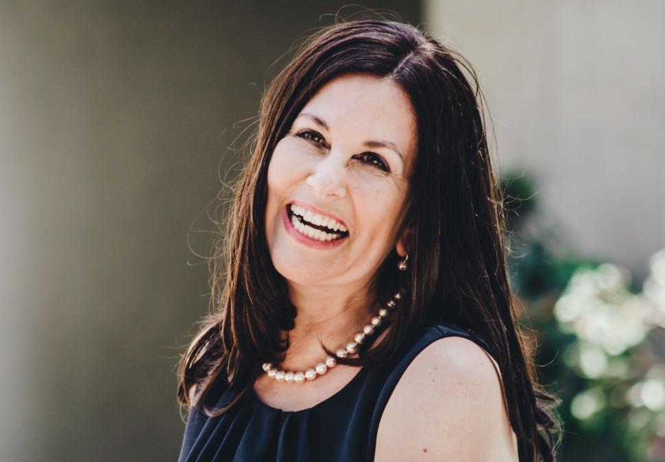 Free Image of Smiling Woman in Black Top and Pearls 
