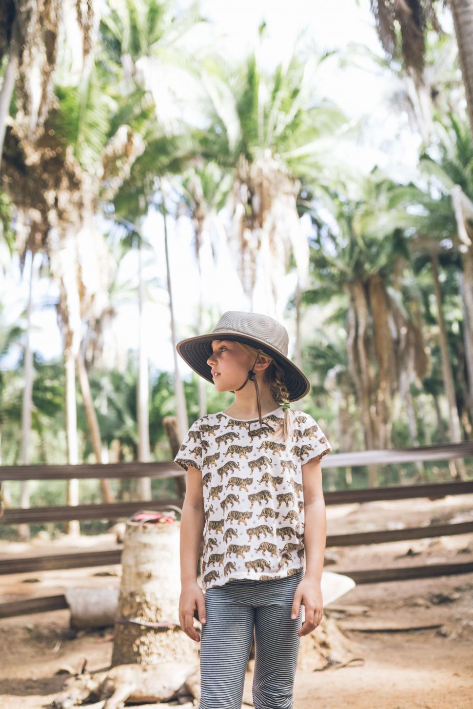Free Image of Little Girl Wearing Hat Standing in Dirt 
