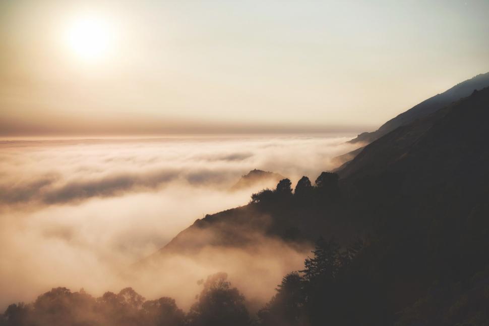 Free Image of Sun Setting Behind Foggy Mountain 