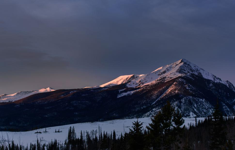 Free Image of Mountain Covered in Snow Under Cloudy Sky 