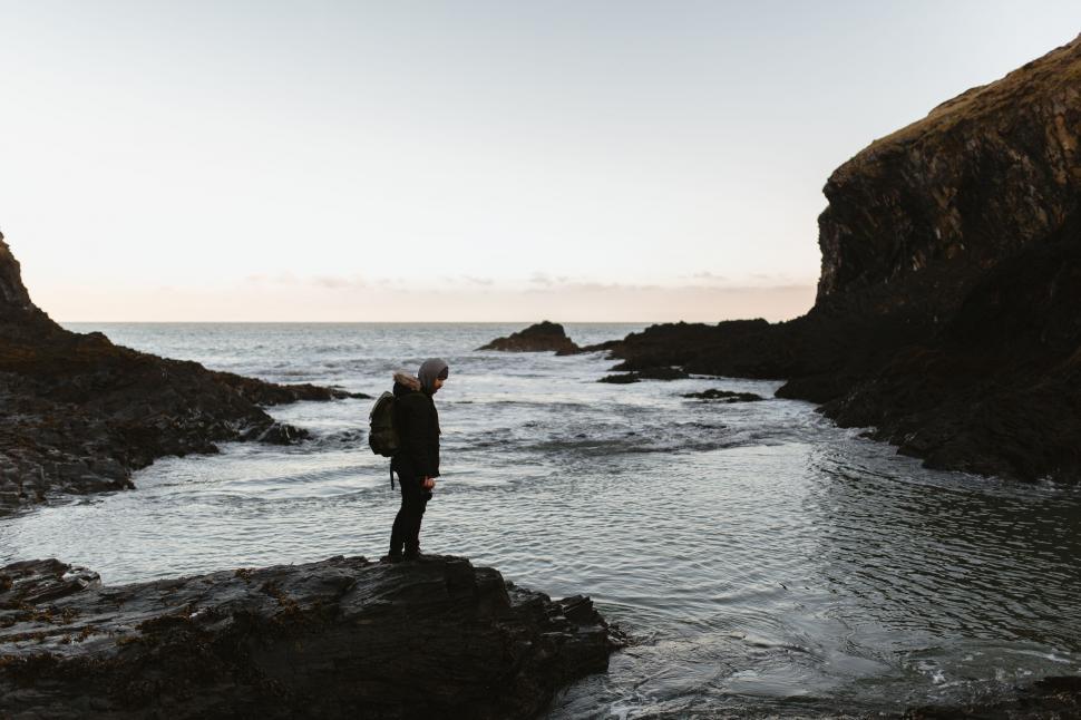 Free Image of Man Standing on Rock in Middle of River 