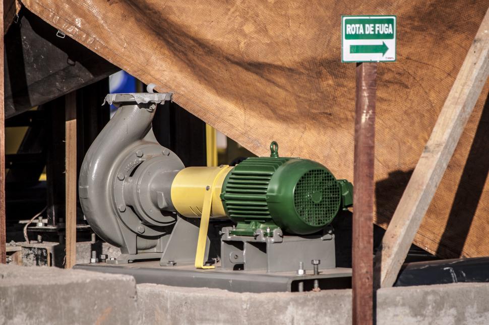 Free Image of Green and White Sign, Pipes, and Brown Tarp 