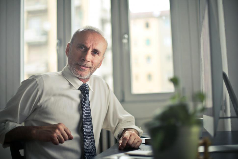 Free Image of Man Sitting on Chair Beside Table in office 
