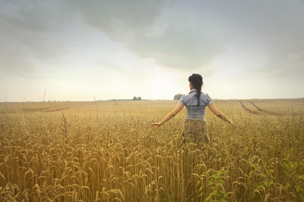 Free Image of Woman Standing on Rice Field during Cloudy Day 