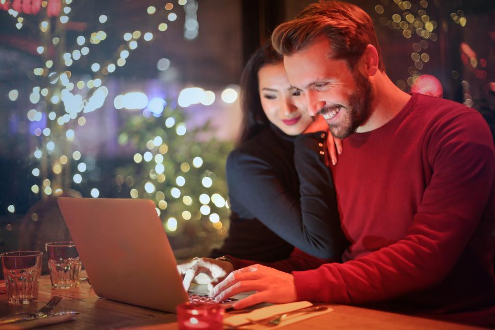 Free Image of Young couple surfing on internet with laptop in a restaurant 