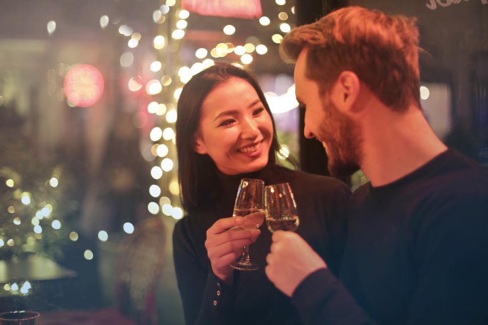 Free Image of Young couple raising toast with glasses of wine 