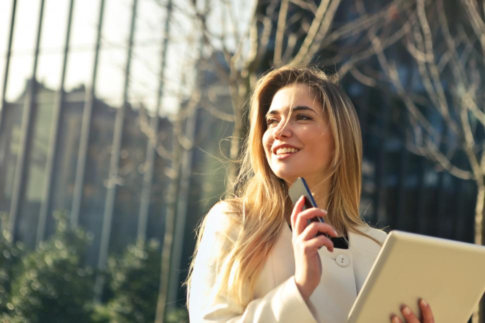 Free Image of Woman Wearing White Top Holding Smartphone and Tablet 