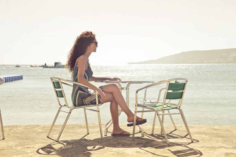 Free Image of Woman Sitting Cross-Legged on Armchair at Seashore 