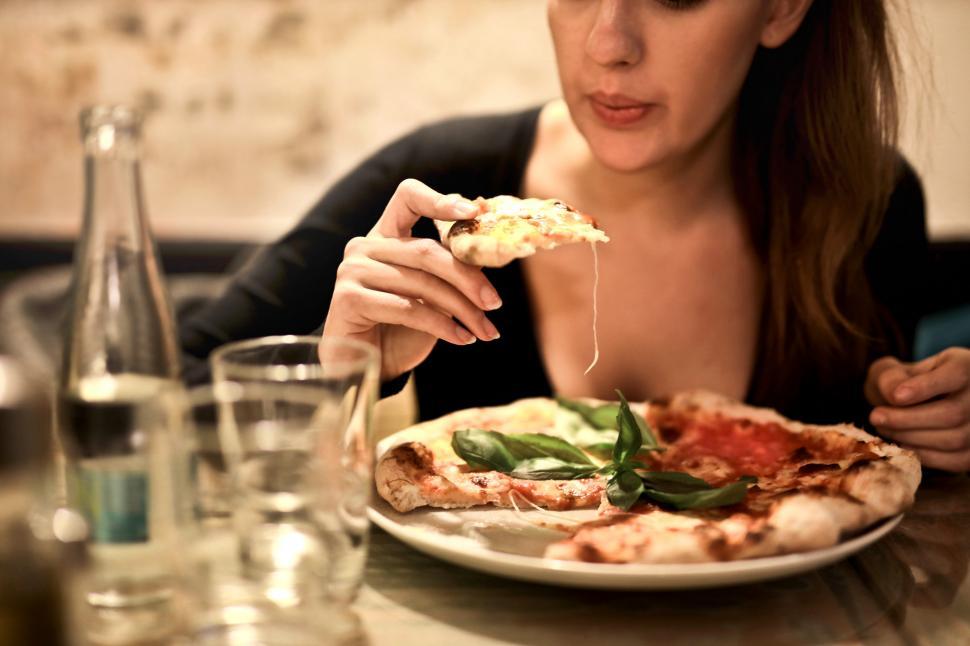 Free Image of Woman Holding Sliced Pizza To Eat 