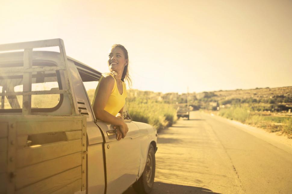 Free Image of Young Beautiful Woman in Yellow Polo Shirt standing inside drive 