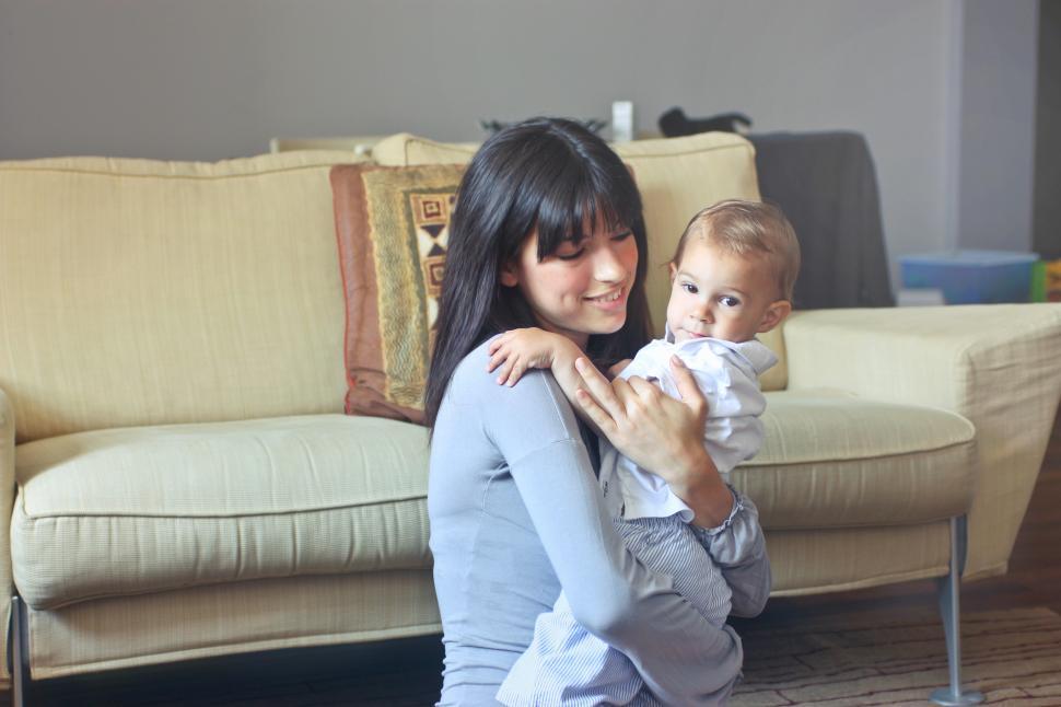 Free Image of Beautiful young mother carrying her child in room 