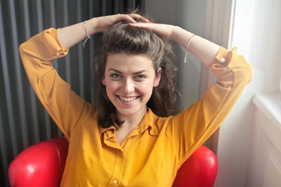 Free Image of Young Woman Wearing Yellow Collared Shirt Lifting Her Hair Up Wi 