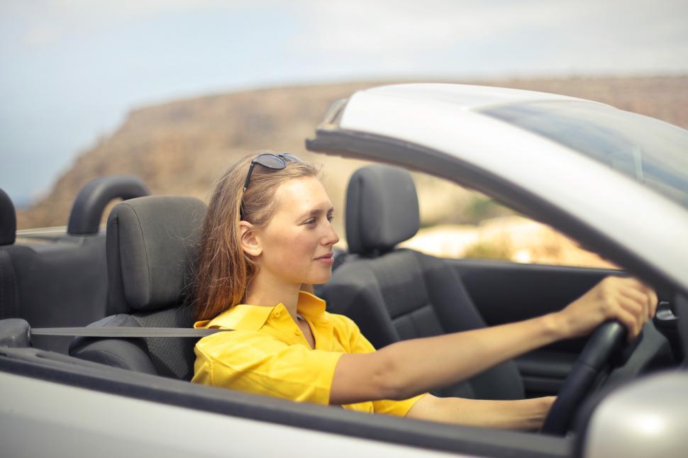 Free Image of Young Woman Wearing Half-Sleeved Yellow Shirt Driving Car 